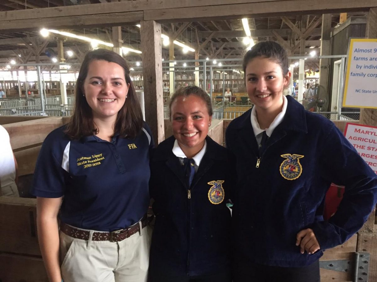 Gracie Goetz and Madison Neilson taking a break from pig shows to talk with Maryland State FFA President. ( Photo Credits:Greg Murrell)
