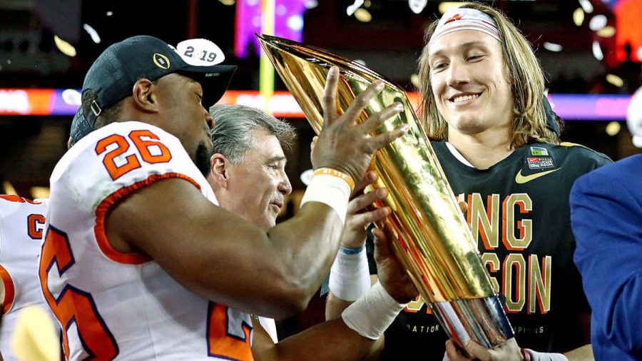 Trevor Lawrence hoists the championship trophy with teammate Adam Choice.     Lawrence became the first true freshman to win the National Championship in 33 years with his 44 - 16 win over Alabama.
