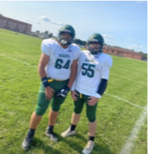 Elian Ortiz(64) standing alongside teammate Shaun Anderson(55). 
He stated that he is excited to continue playing for NHHS.