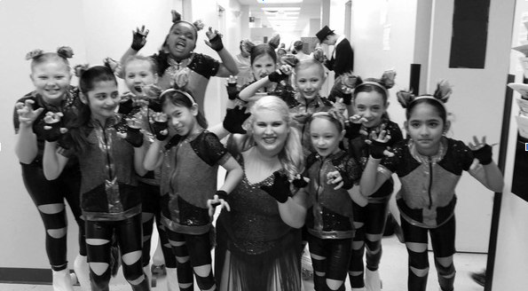 Photo Credit: Bryn Cespedes 
This photo featured Bryn’s instructor in the center with Bryn just to the right of her.
It also represents the costumes they wear for recitals.

