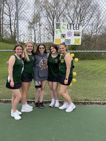Sophomores Cara Dyke, Emily Johsnon, Stella Manns, and Mekenzie McCann pose with Greer Strine on senior night. On April 25 the team faced North East and beat them 8-3. 