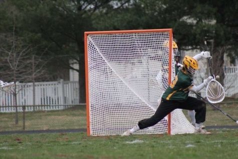 Senior goalie Ryan Tracy saves a shot from going into the goal. The varsity team ended their season with a record of 10-6.