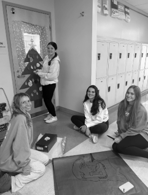 Senior Alayna Shrodes, juniors Mia Honig and Peyton Dawson, and freshman Evangeline Brown worked together to decorate this door. The doors will be judged the week of Dec. 16.
